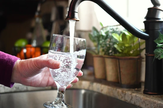 female-filling-a-glass-goblet-of-water-from-the-tap-after water filter